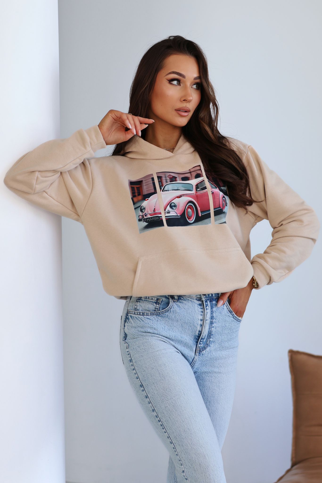 Beżowa bluza z nadrukiem vintage i jasne jeansy, casualowa stylizacja na co dzień w modnym stylu streetwear.